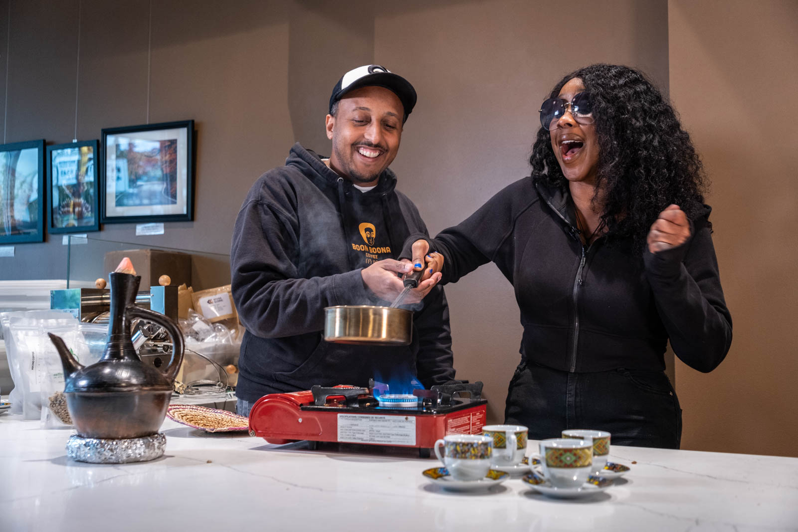Besa Gordon laughing with the owner of Boon Boona Coffee during an Ethiopian coffee ceremony on a shoot